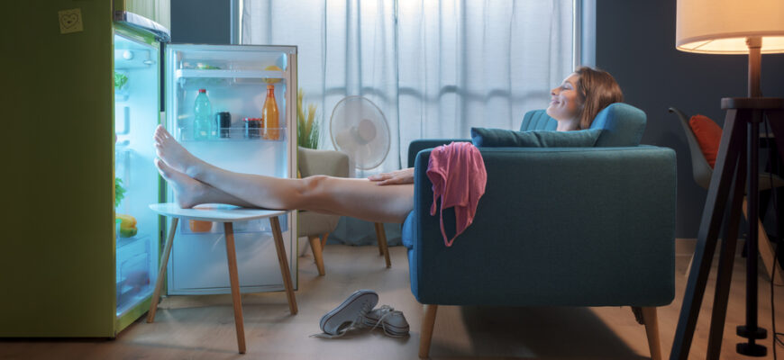 Woman,Cooling,Herself,In,Front,Of,The,Open,Fridge,At